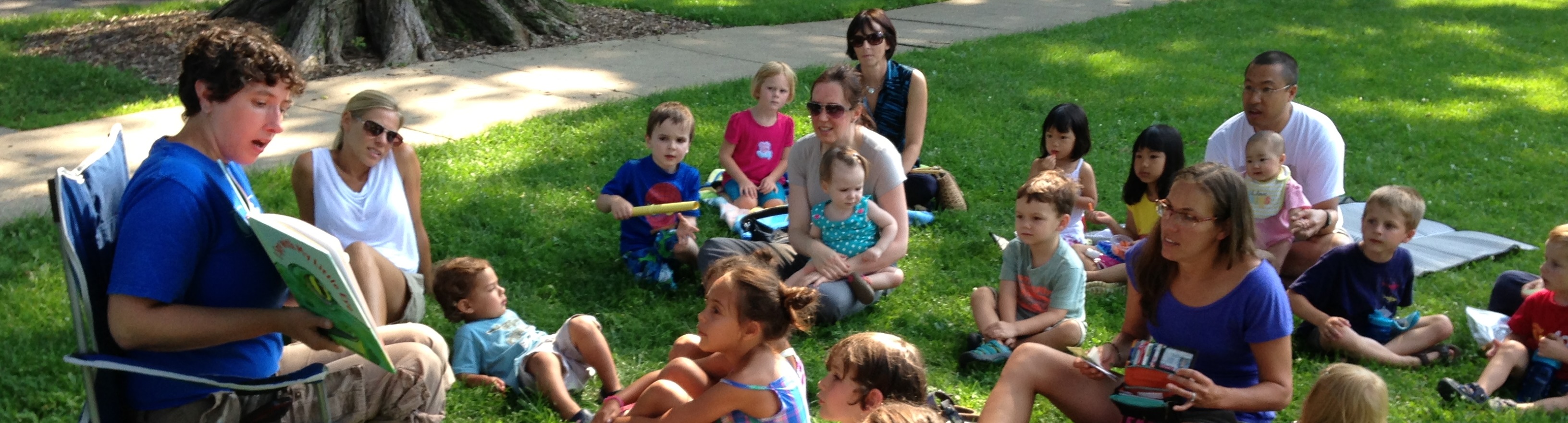 Librarian and families reading stories in the park
