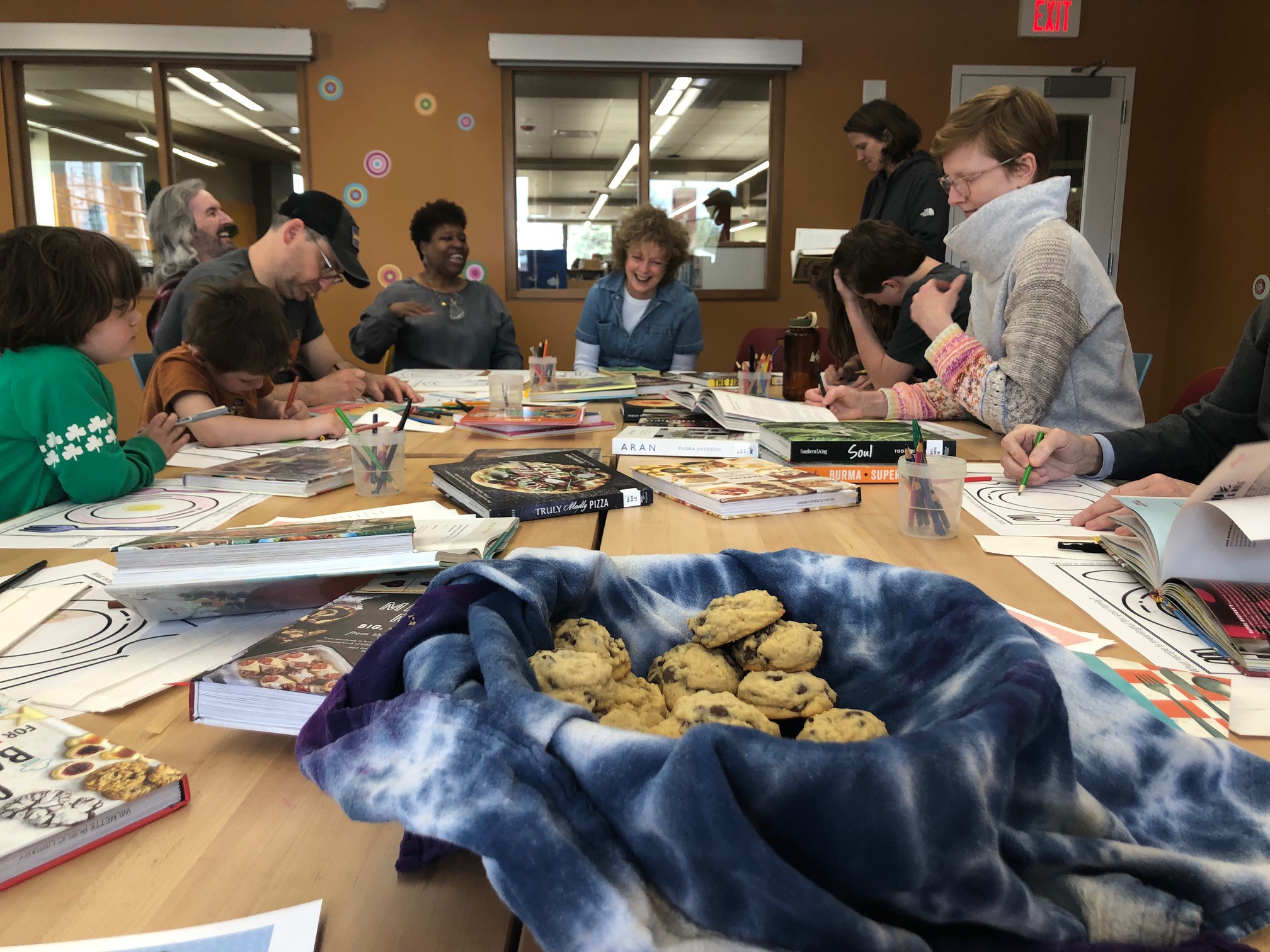 Families talking with a basket of cookies in the foreground