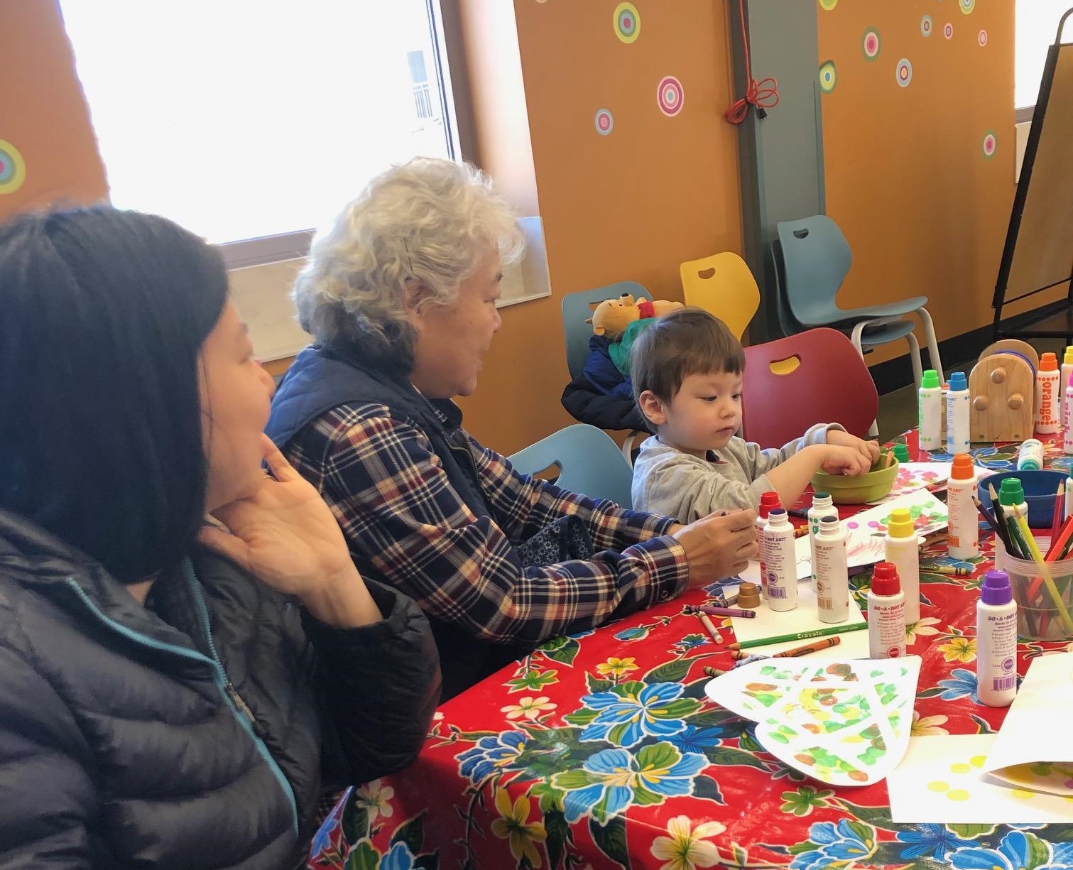 Three generations of family members make an art project together