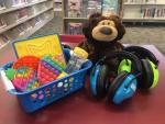 headphones, stuffed bear and sensory toys on a red table