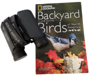 A pair of Nikon binoculars on the book "Guide to the Backyard Birds of North America."