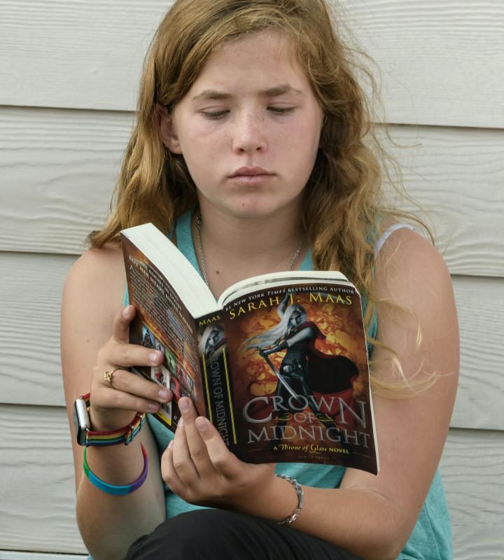 Teen Book Lists linked image showing teen girl reading YA novel