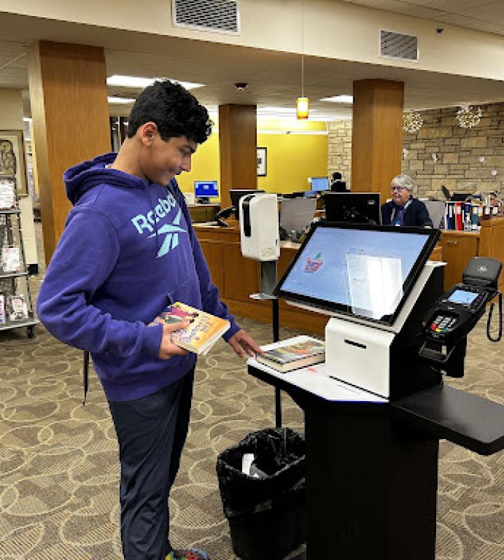 Teen using check out machine