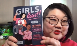 An image of author KaeLyn Rich holding the book Girls Resist!